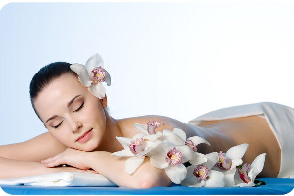 Woman resting in beauty spa salon  with flowers - colored background